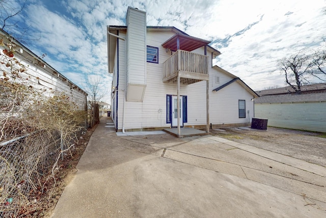 back of house with a balcony and a patio