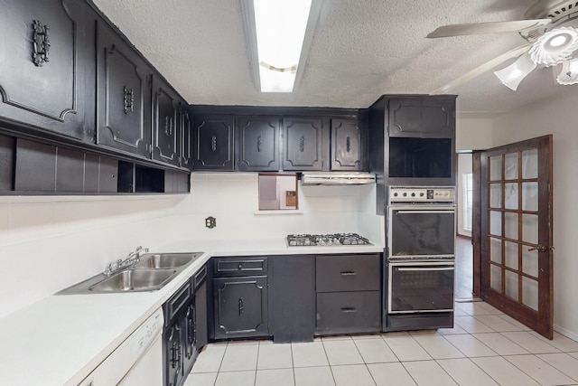 kitchen featuring double wall oven, sink, light tile patterned floors, and stainless steel gas cooktop