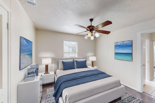 bedroom with dark hardwood / wood-style flooring, a textured ceiling, and ceiling fan