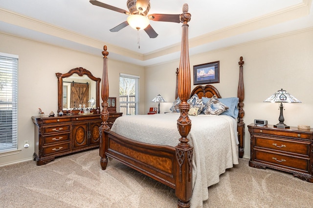 bedroom with crown molding, ceiling fan, a raised ceiling, and light carpet