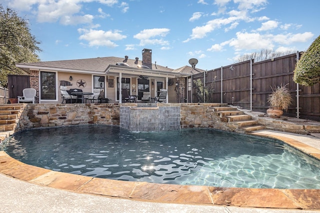 view of swimming pool with pool water feature, ceiling fan, and a patio