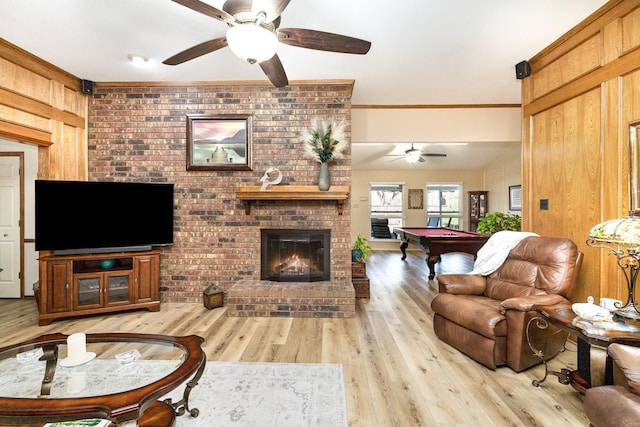 living room featuring crown molding, billiards, light hardwood / wood-style floors, brick wall, and wood walls