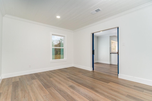 spare room featuring crown molding and light wood-type flooring