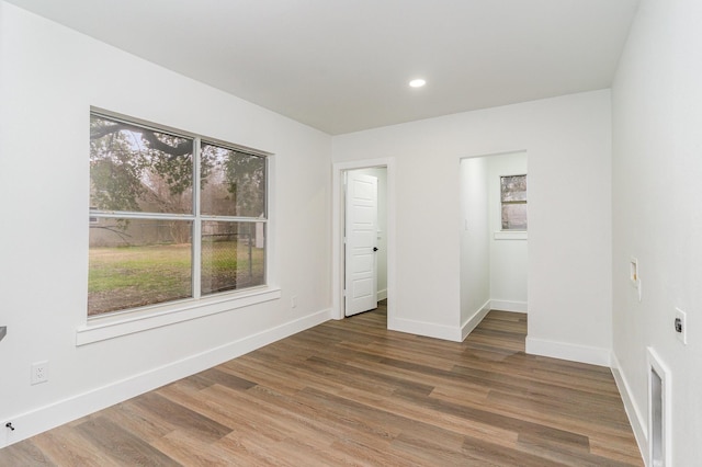 empty room featuring a healthy amount of sunlight and hardwood / wood-style floors