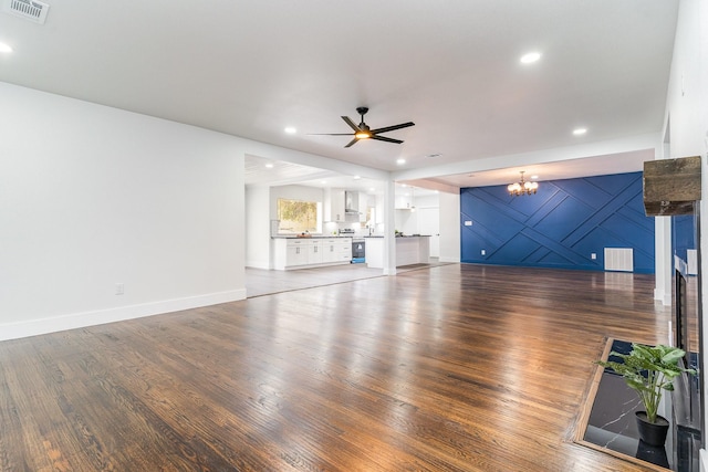 unfurnished living room with hardwood / wood-style flooring and ceiling fan with notable chandelier