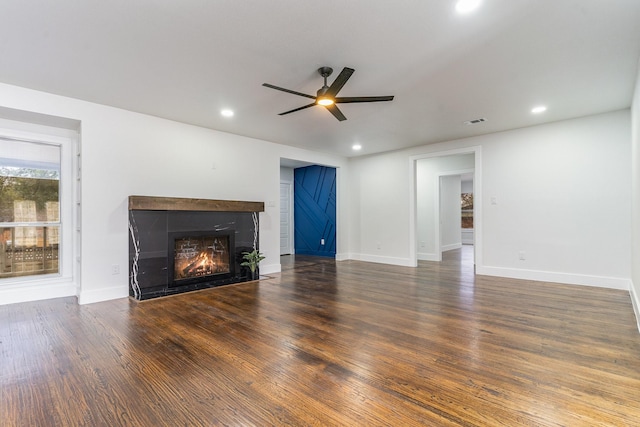 unfurnished living room with dark hardwood / wood-style flooring and ceiling fan