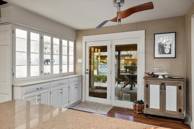 doorway featuring dark wood-type flooring and ceiling fan