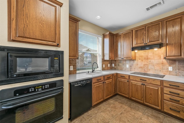 kitchen featuring sink, decorative backsplash, and black appliances