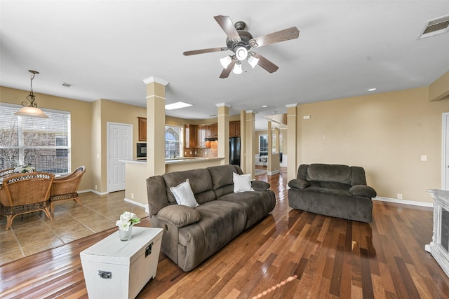 living room with hardwood / wood-style floors, sink, ceiling fan, and ornate columns