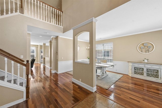 entrance foyer with crown molding, a chandelier, and hardwood / wood-style flooring