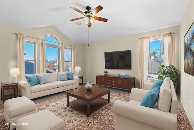 living room with a water view, lofted ceiling, plenty of natural light, and ceiling fan