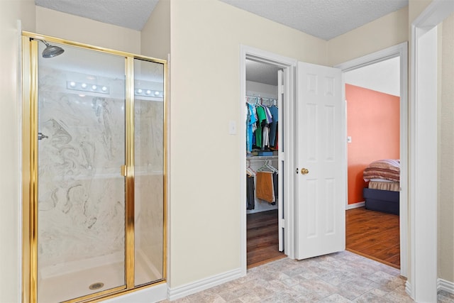 bathroom featuring a shower with door and a textured ceiling