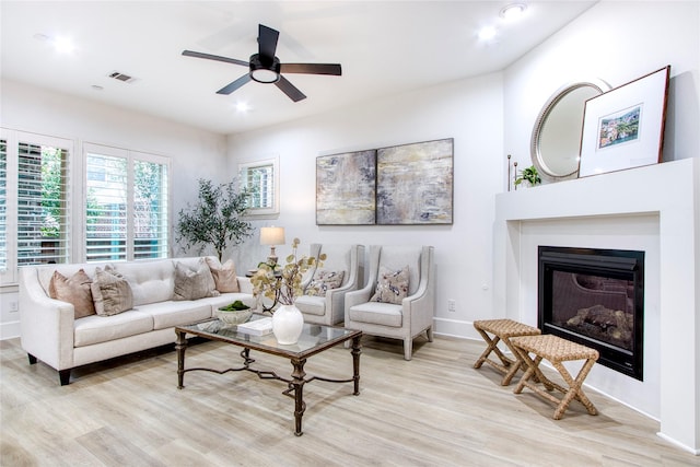 living room featuring ceiling fan and light hardwood / wood-style flooring