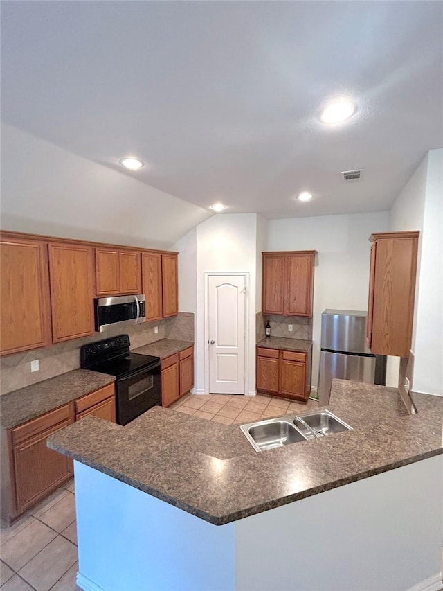 kitchen featuring sink, light tile patterned floors, backsplash, stainless steel appliances, and kitchen peninsula