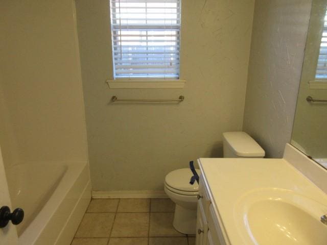 bathroom with vanity, toilet, tile patterned flooring, and a washtub