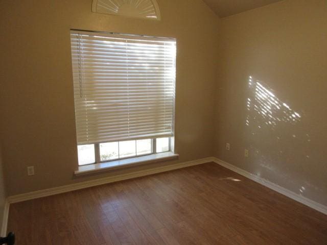 unfurnished room with lofted ceiling and dark hardwood / wood-style flooring