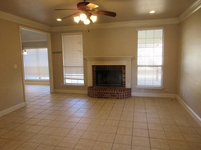 unfurnished living room featuring light tile patterned flooring, ceiling fan, ornamental molding, and a brick fireplace