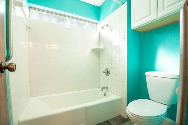 bathroom with toilet and tiled shower / bath combo