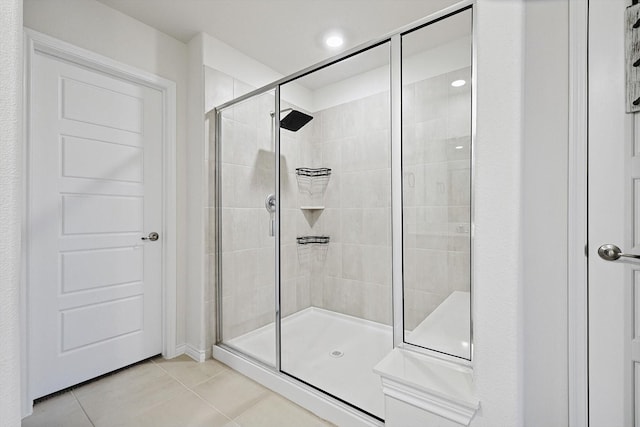 bathroom with a shower with shower door and tile patterned flooring