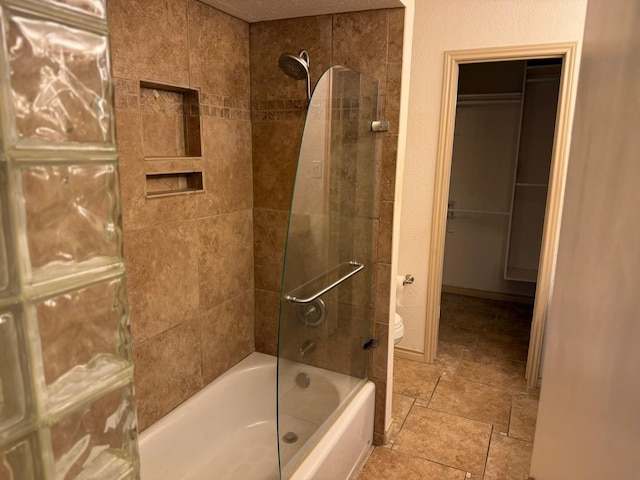 bathroom with tiled shower / bath and toilet