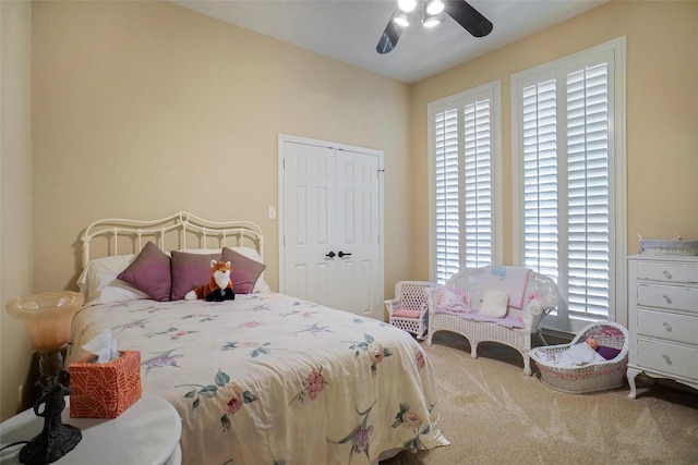 carpeted bedroom with ceiling fan and a closet