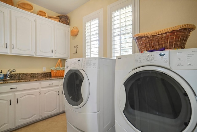 washroom with light tile patterned flooring, cabinets, sink, and washing machine and dryer