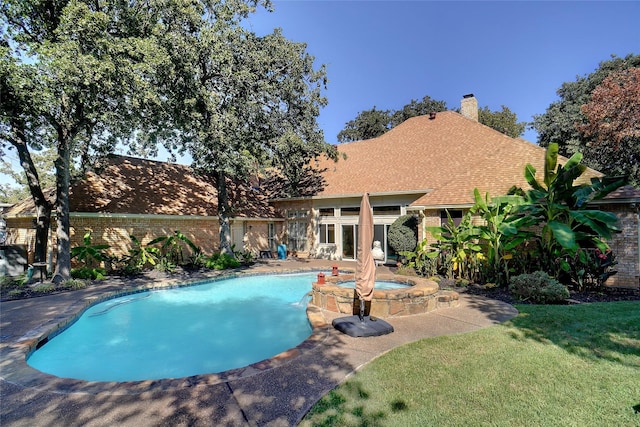 view of swimming pool featuring an in ground hot tub and a yard