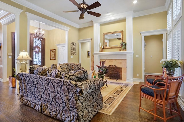 living room with ceiling fan with notable chandelier, ornamental molding, dark hardwood / wood-style flooring, and a premium fireplace