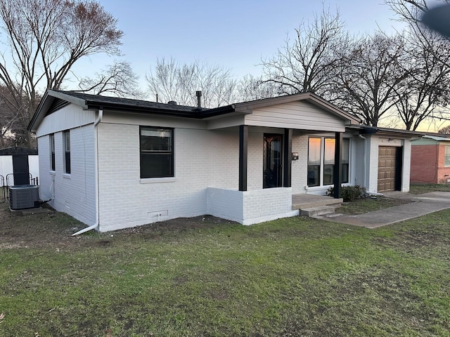 view of front of house featuring brick siding, crawl space, an attached garage, central AC, and a front yard