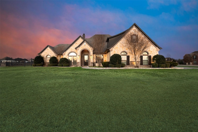 french country home featuring a lawn