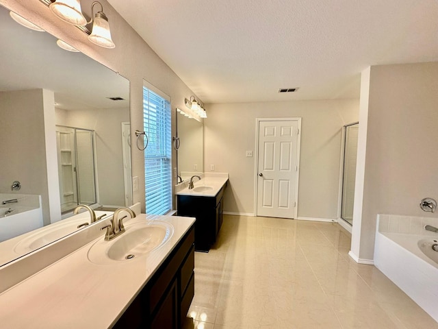 bathroom featuring vanity, independent shower and bath, and a textured ceiling