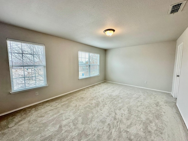 unfurnished room featuring light carpet and a textured ceiling