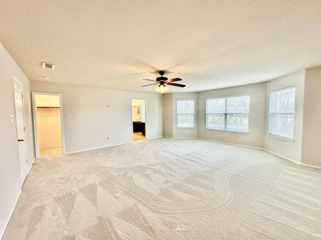 carpeted empty room with ceiling fan and a textured ceiling