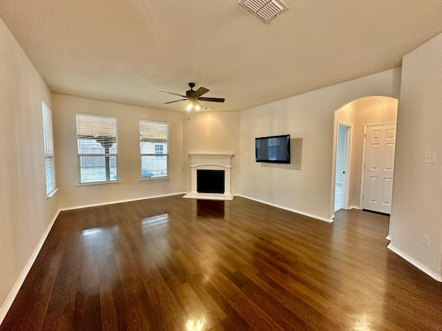 unfurnished living room with dark hardwood / wood-style flooring and ceiling fan