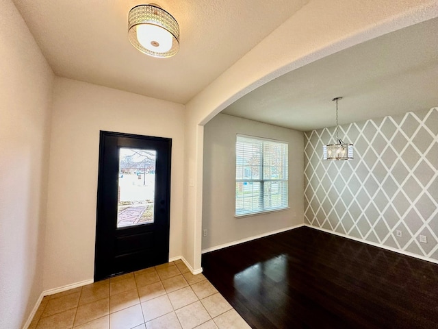 tiled entrance foyer featuring a notable chandelier