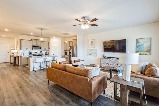 living room with recessed lighting, ceiling fan, and wood finished floors