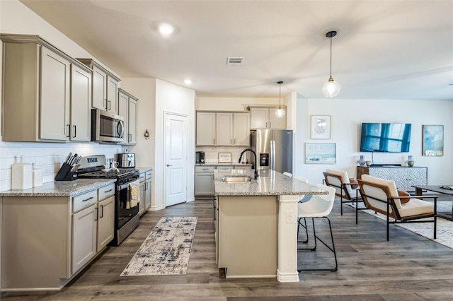 kitchen with dark wood finished floors, gray cabinets, visible vents, appliances with stainless steel finishes, and a sink