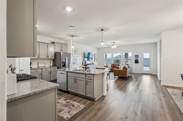 kitchen featuring stainless steel appliances, wood finished floors, a sink, visible vents, and gray cabinets