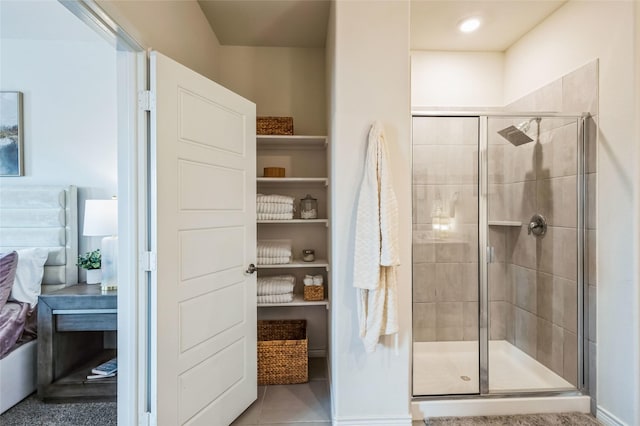 ensuite bathroom with a stall shower, tile patterned floors, and ensuite bathroom