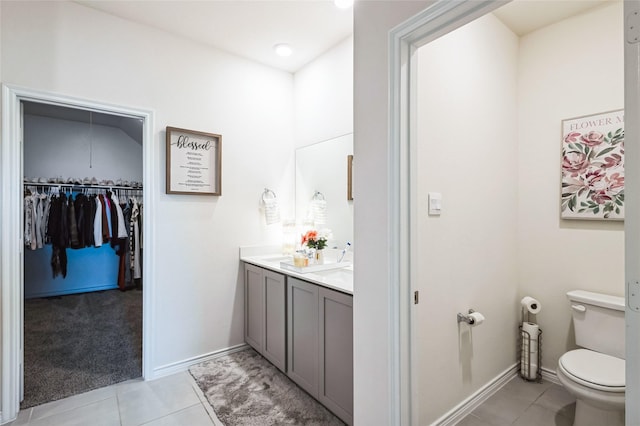 full bathroom with toilet, tile patterned flooring, double vanity, and baseboards