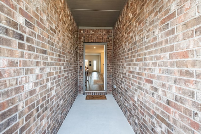 doorway to property featuring brick siding