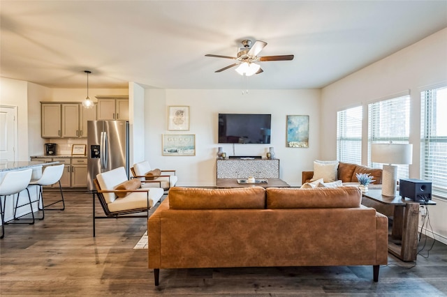 living area with ceiling fan and dark wood-style flooring