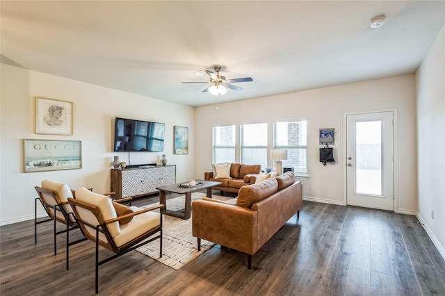 living area with a ceiling fan, dark wood finished floors, and baseboards