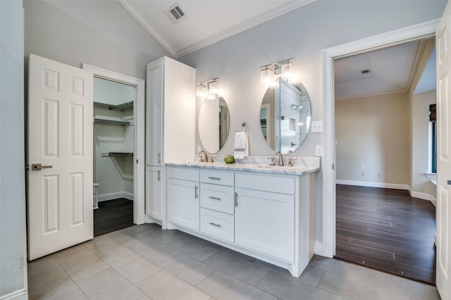 bathroom with tile patterned floors, ornamental molding, and vanity