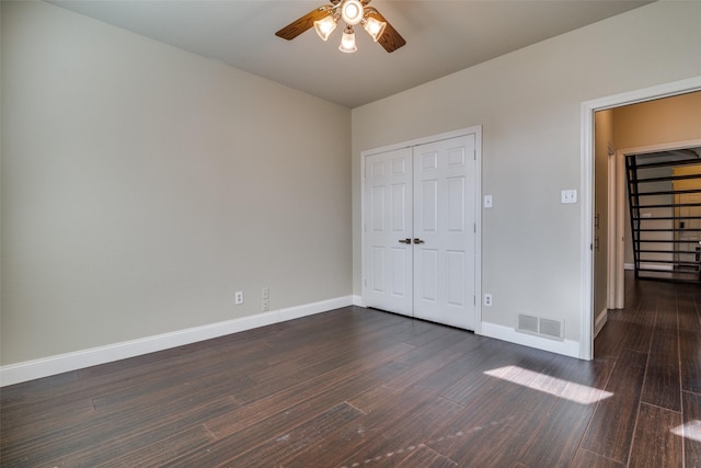 unfurnished bedroom featuring ceiling fan, dark hardwood / wood-style flooring, and a closet