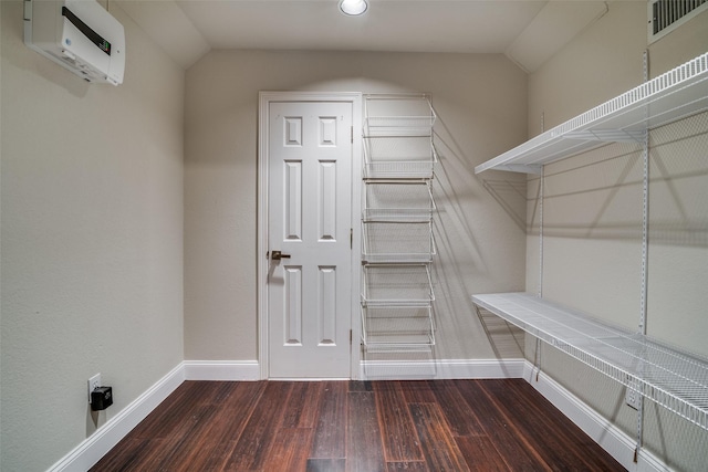 walk in closet with dark wood-type flooring and vaulted ceiling