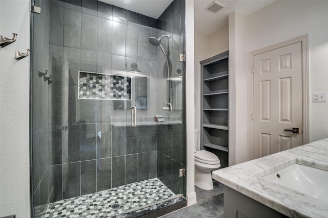 bathroom featuring vanity, walk in shower, and toilet