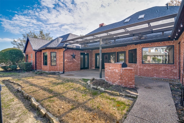 back of property featuring a pergola, a yard, and a patio