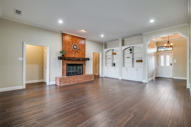 unfurnished living room with a brick fireplace, crown molding, and dark hardwood / wood-style floors