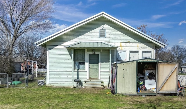 rear view of house featuring a lawn